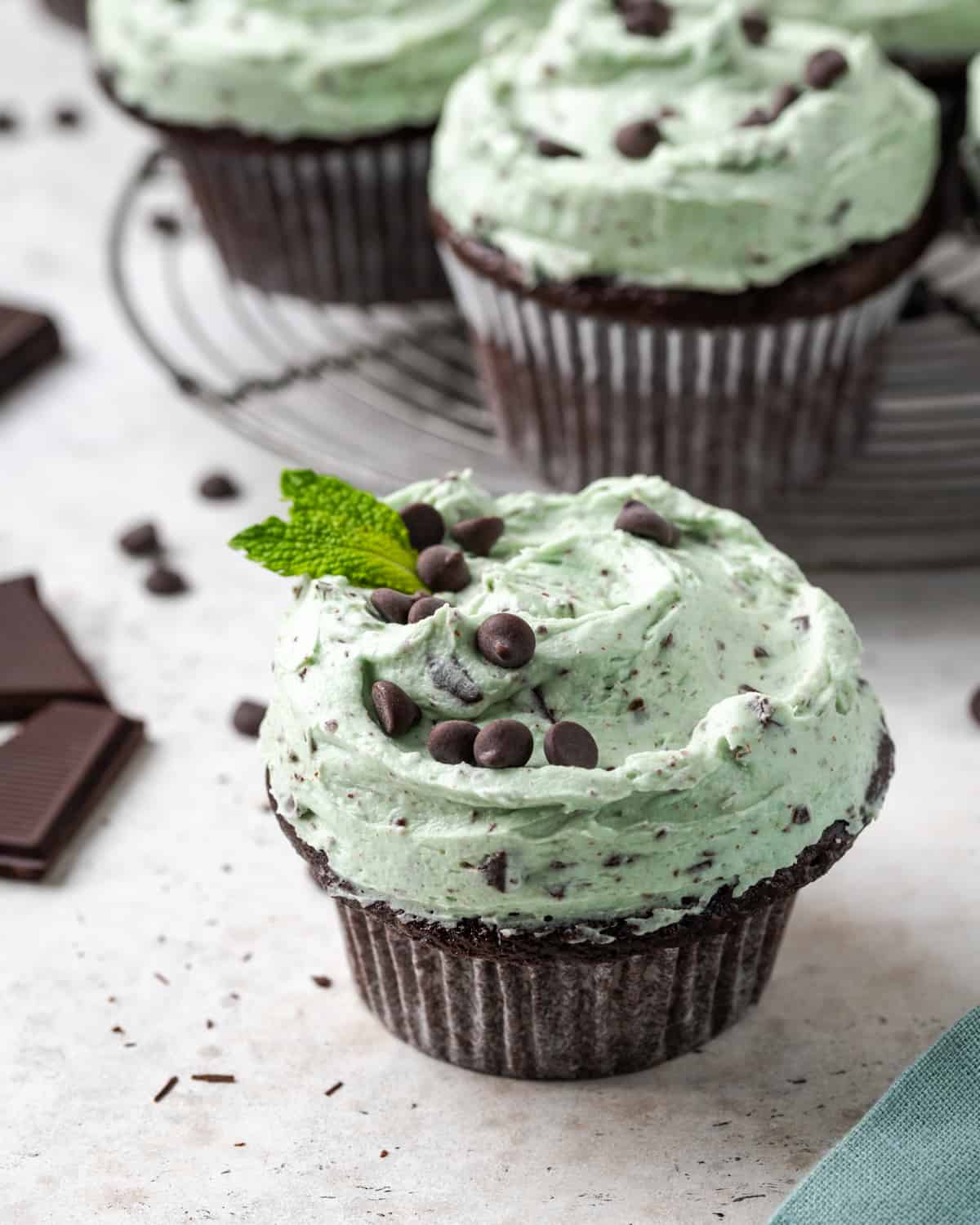 A batch of mint chocolate cupcakes sitting on a wire cooling rack. 
