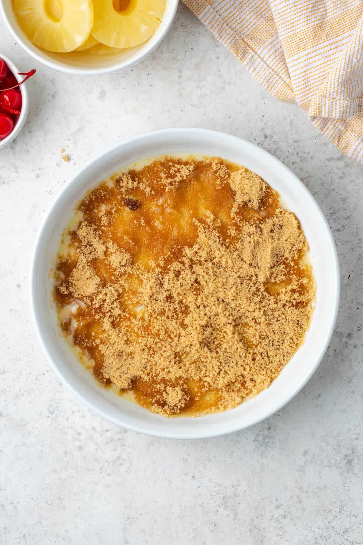 Brown sugar sprinkled over the melted butter in the pie plate.