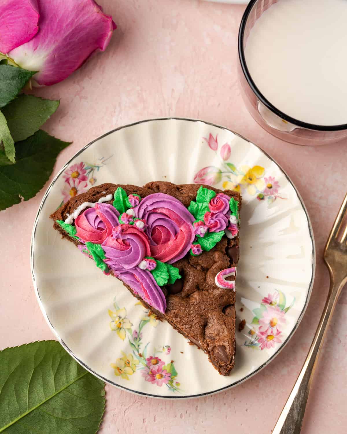 A slice of a cookie heart served on a floral pattern plate.