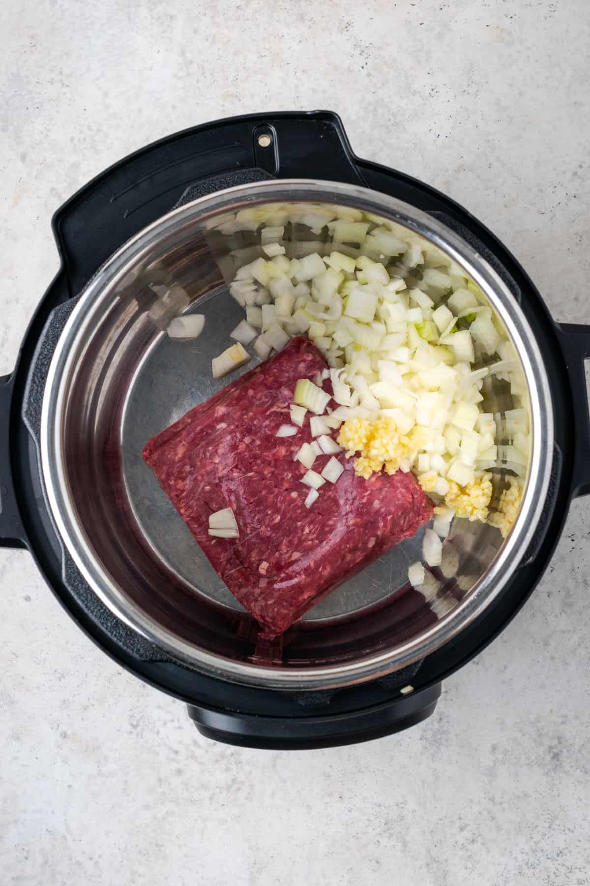 Ground beef, onion and garlic being sauteed in the instant pot. 