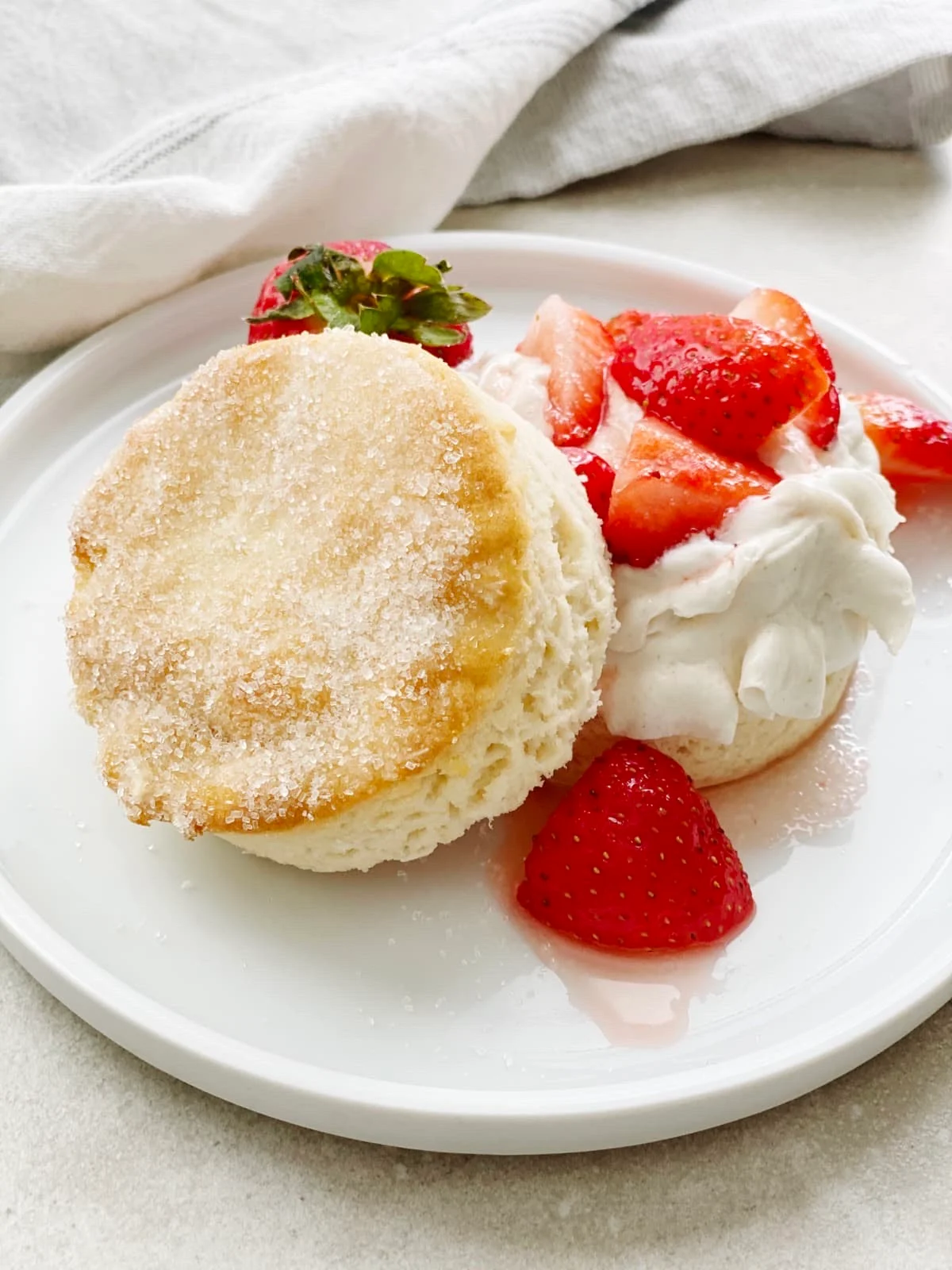 A gluten free strawberry short cake served on a small dessert plate.
