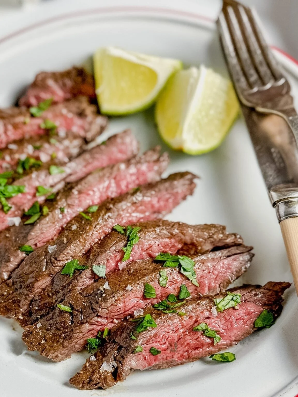 Sliced steak sitting on a large serving platter.