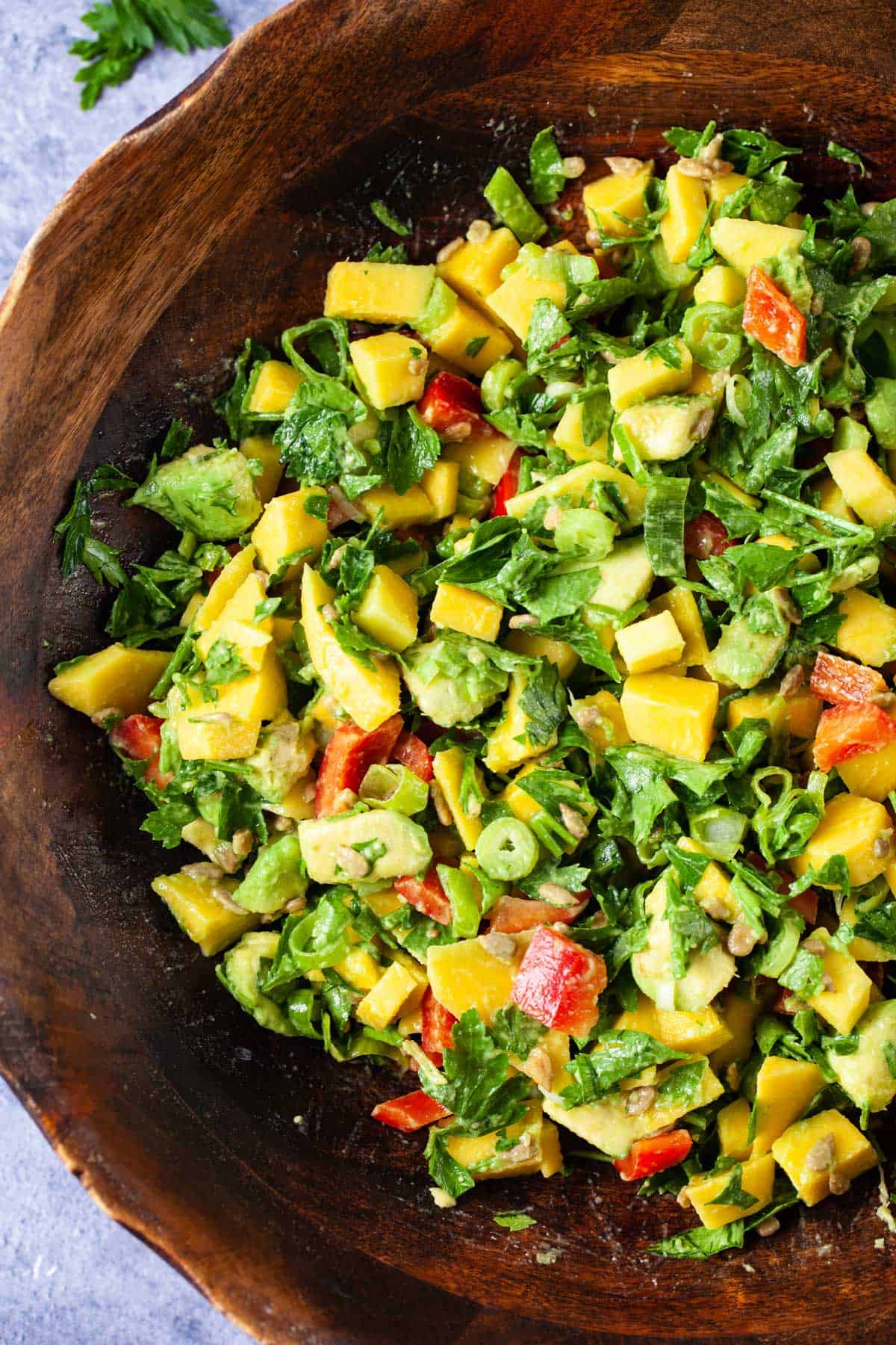 Mango avocado salad served in a large wooden bowl.
