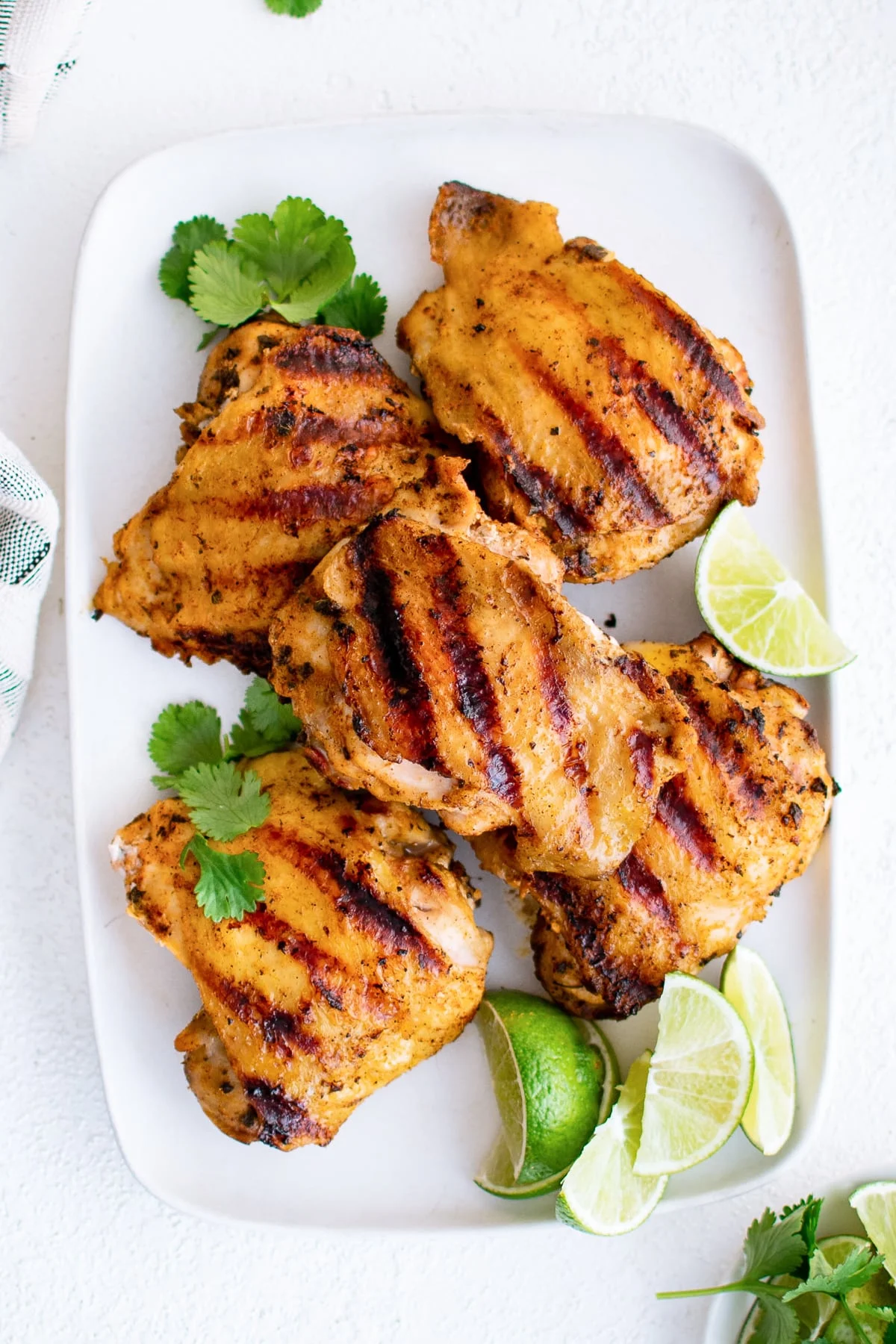 Several pieces of grilled chicken on a serving platter.