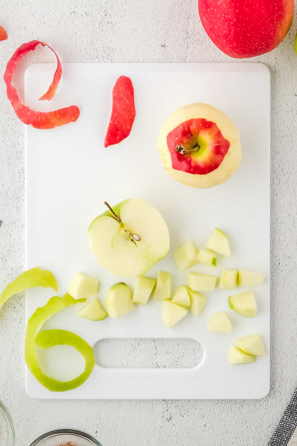 Peeled and cut apples lying on a cutting board.