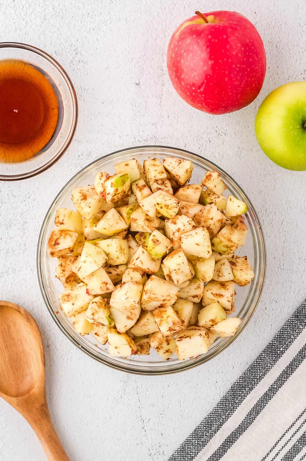 Apple pieces, butter and cinnamon combined in a large mixing bowl.