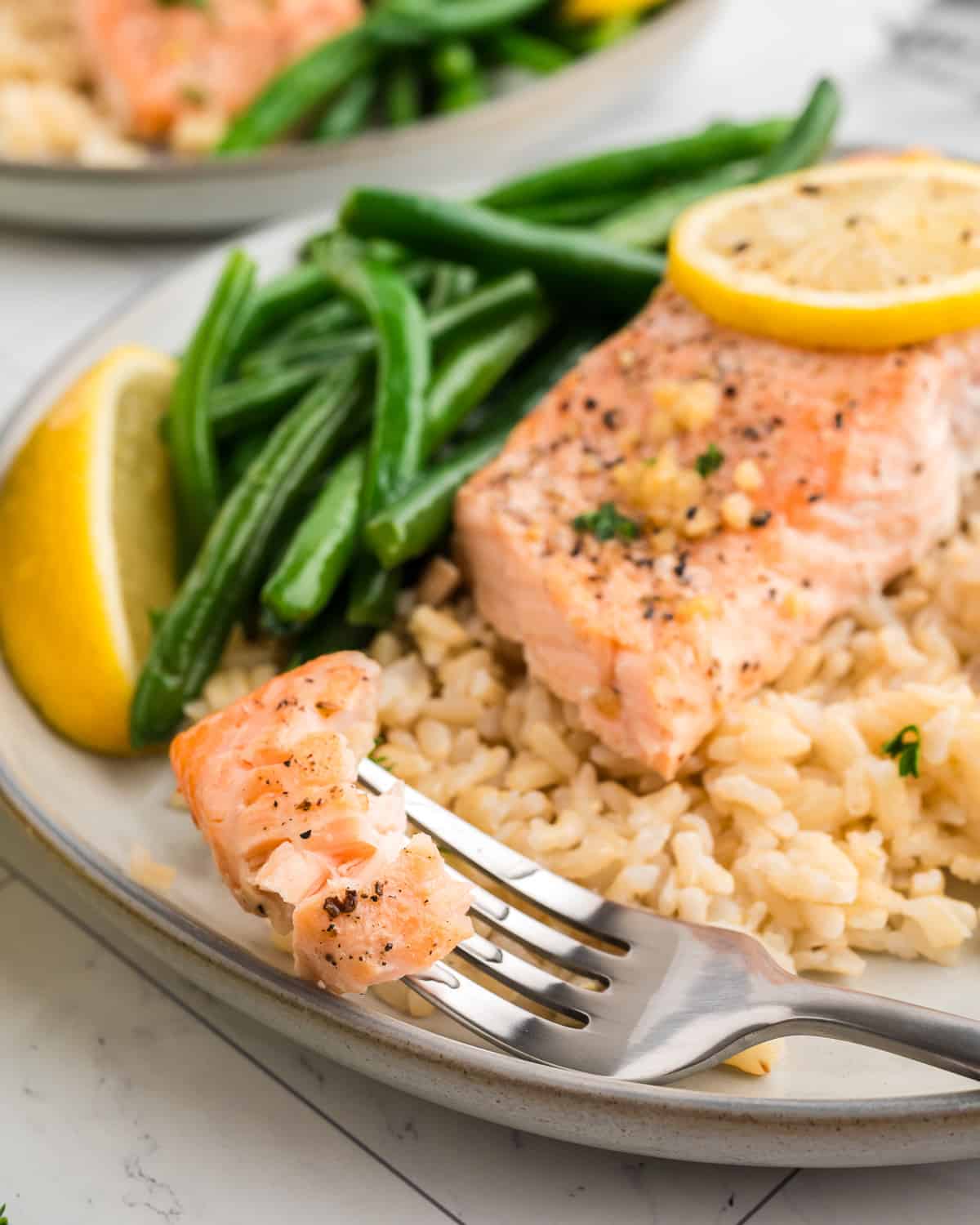 A bite of lemon pepper salmon on a fork. 