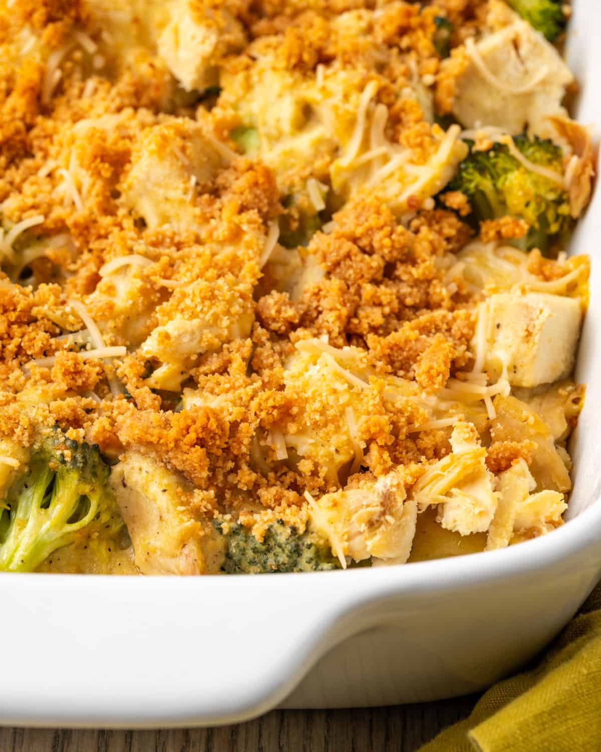 A freshly baked chicken broccoli and potato casserole served in a white baking dish.