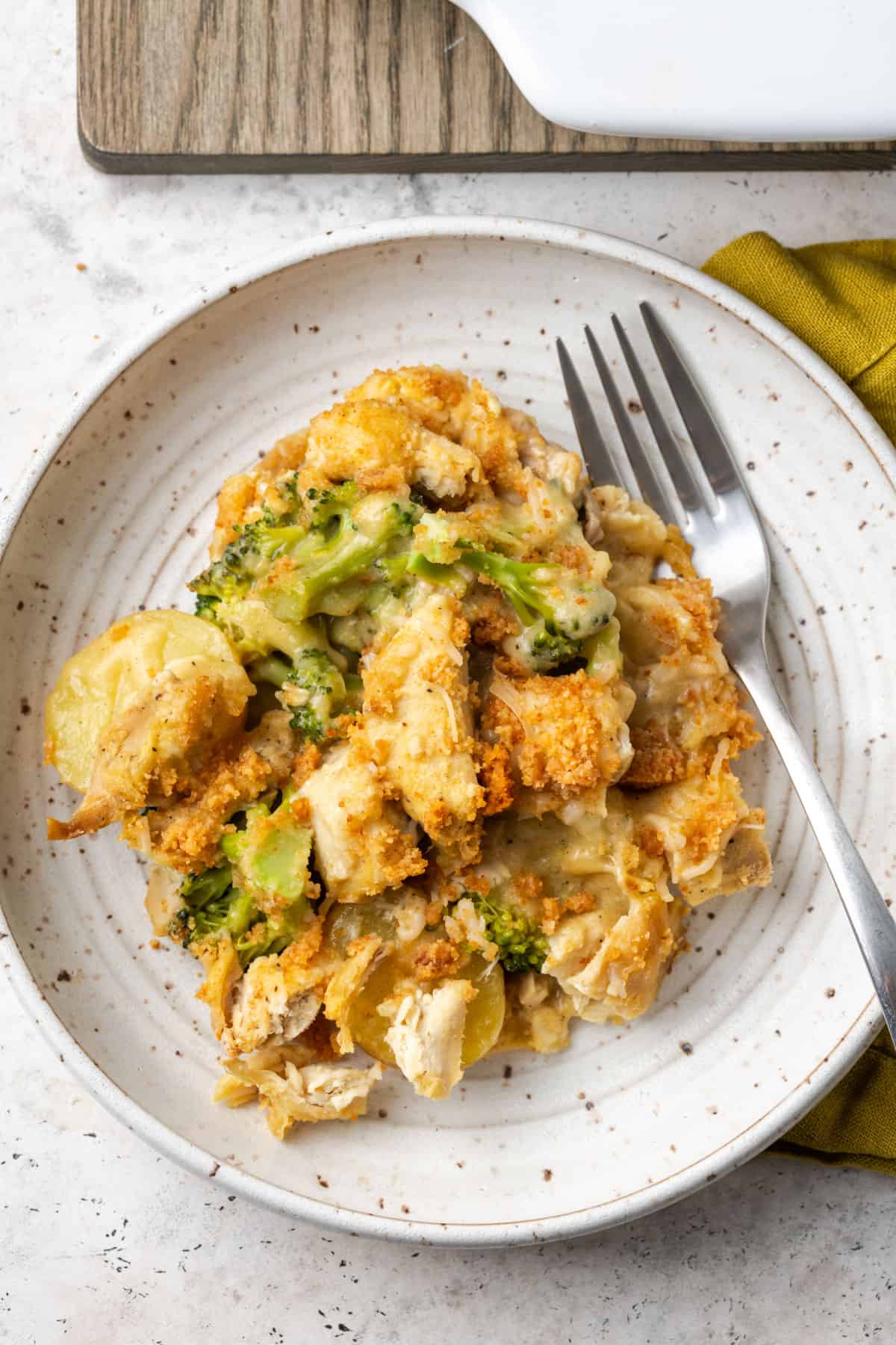 A serving of chicken broccoli potato bake on a white plate.