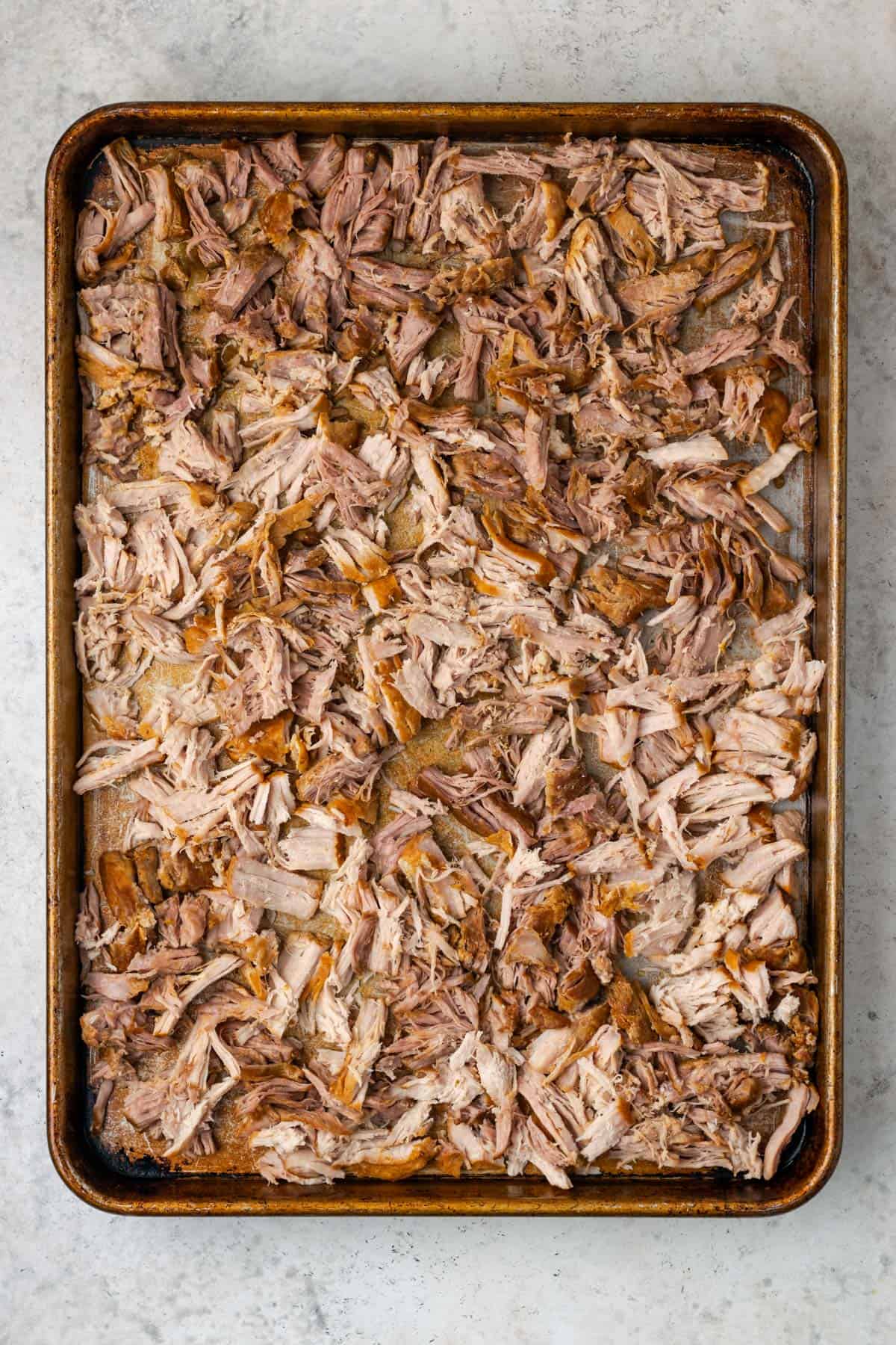 Shredded pork spread on a baking sheet. 