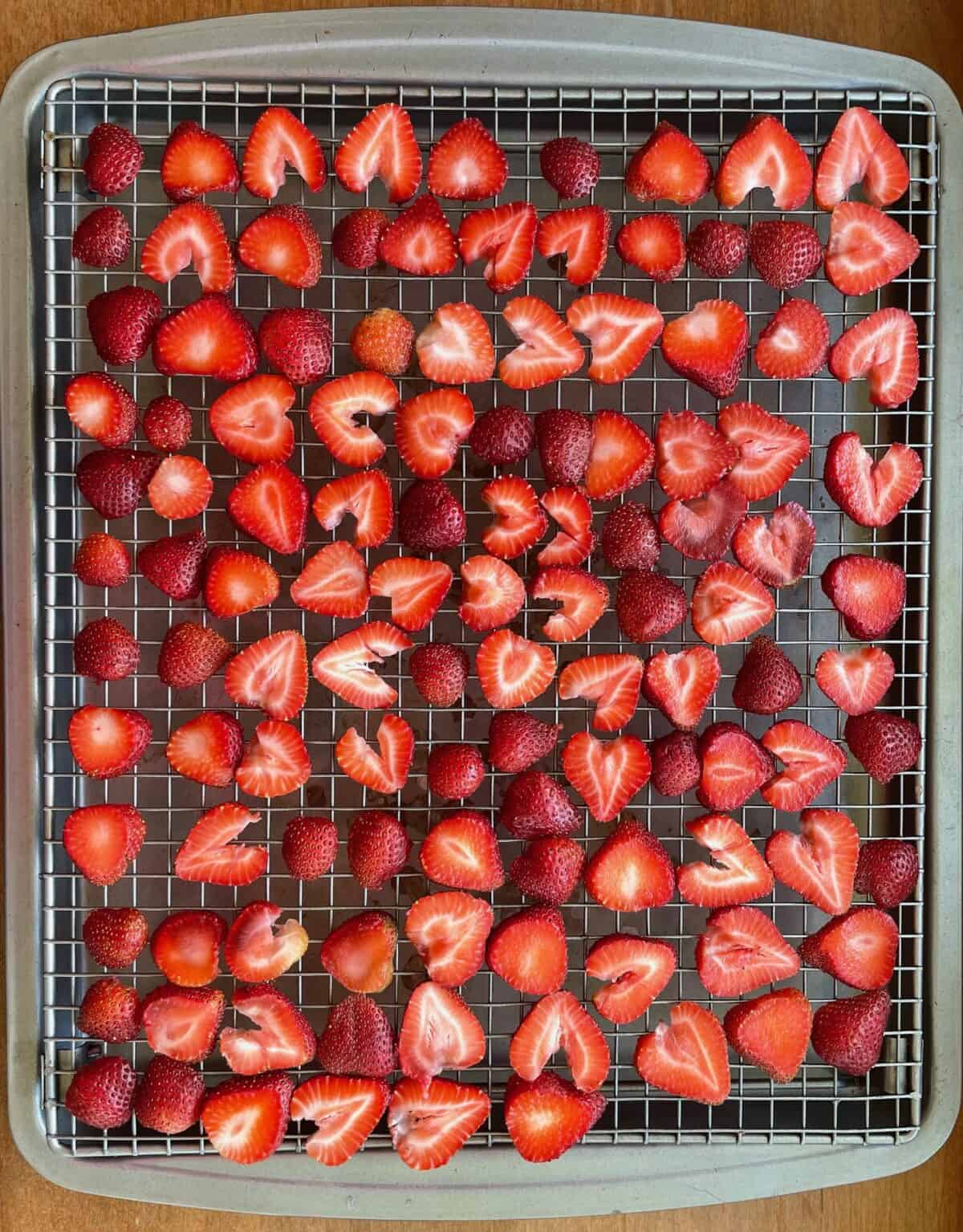Dehydrated strawberry slices on a metal cooling rack.