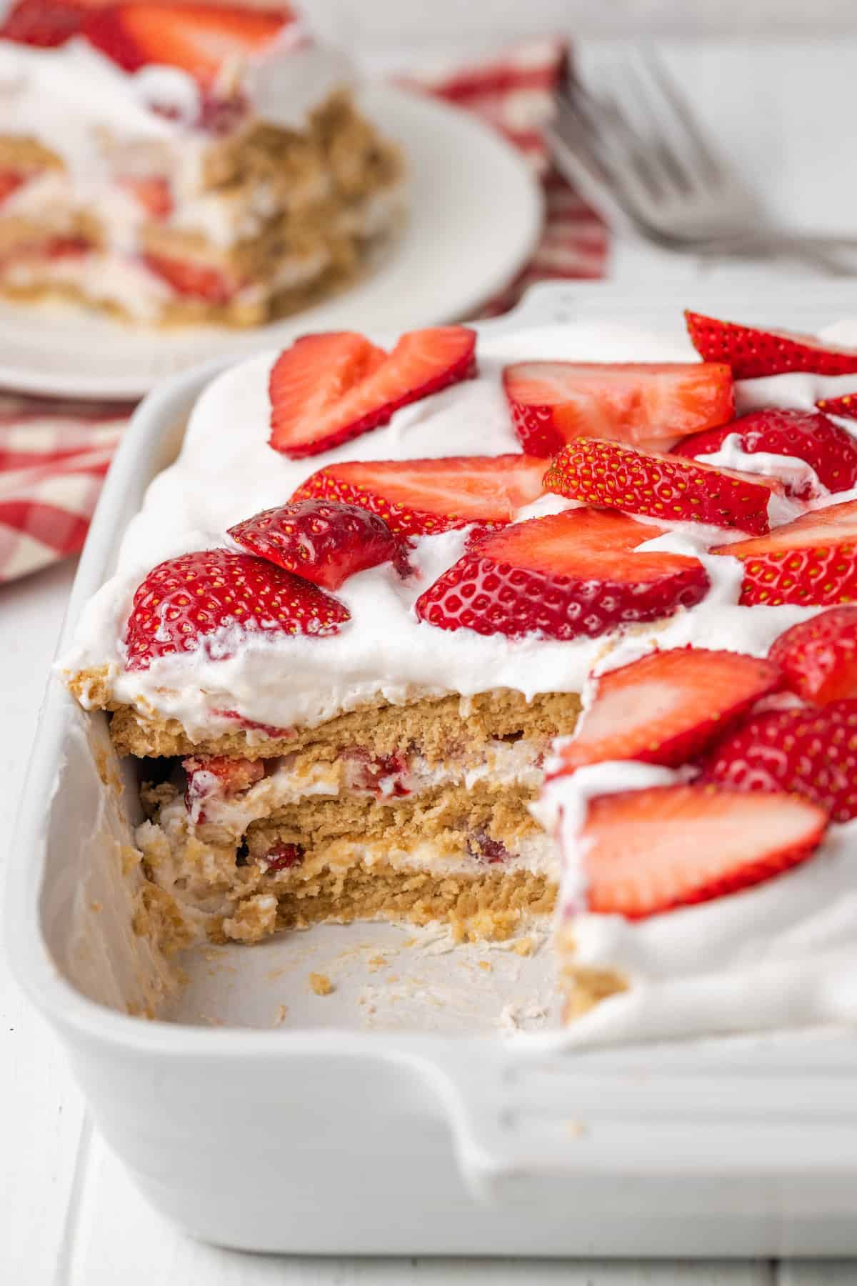 A strawberry icebox cake with a slice cut out.