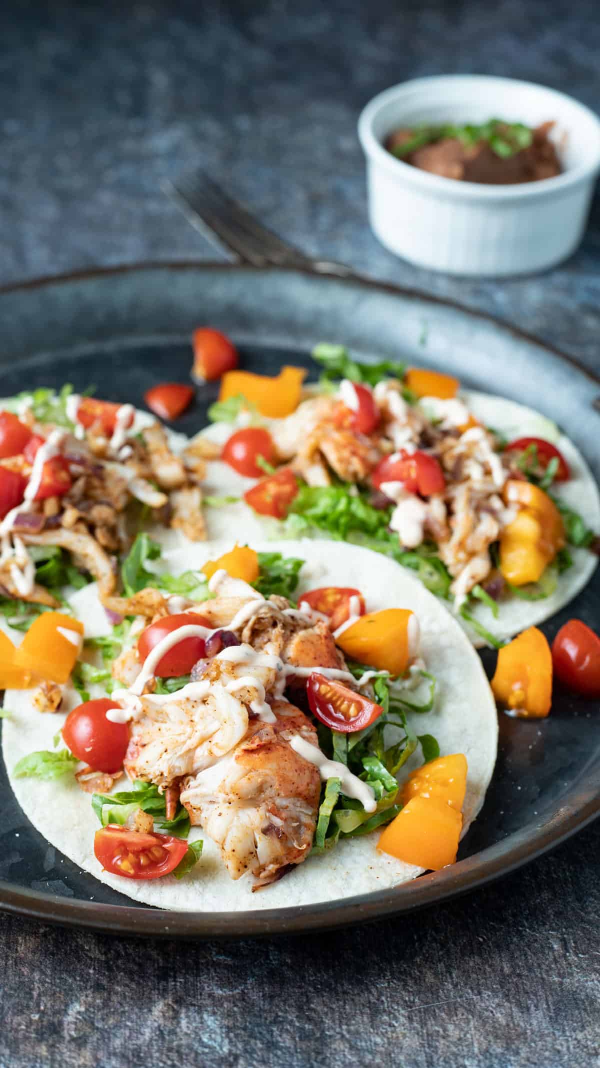 Three lobster tacos on a dinner plate.