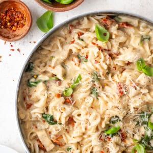 A pan filled with marry me chicken pasta sitting on a white table.