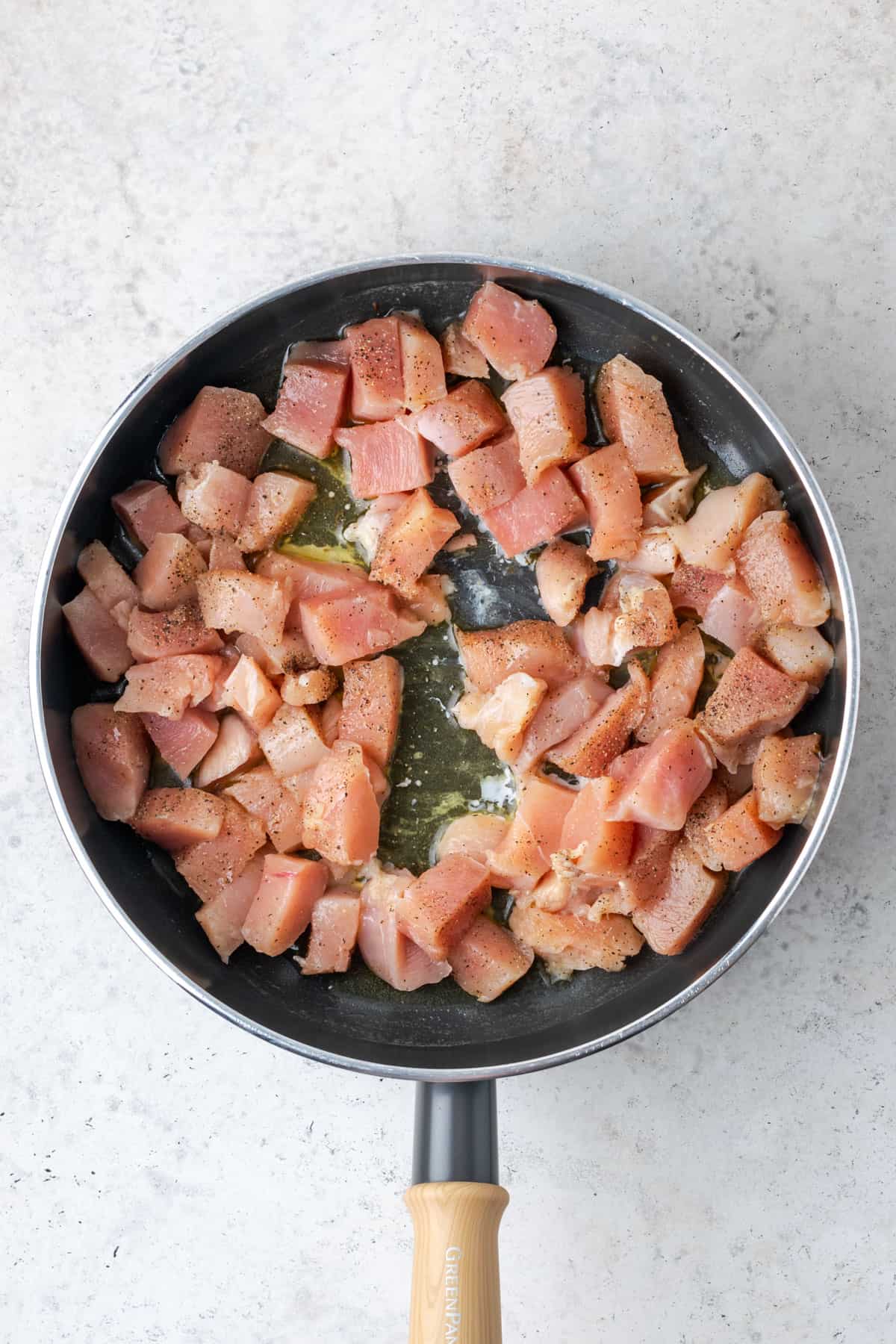 Chicken pieces being cooked in the saute pan.