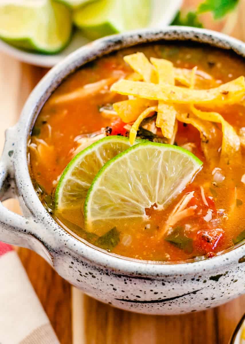 Mexican lime soup served in a rustic ceramic crock.