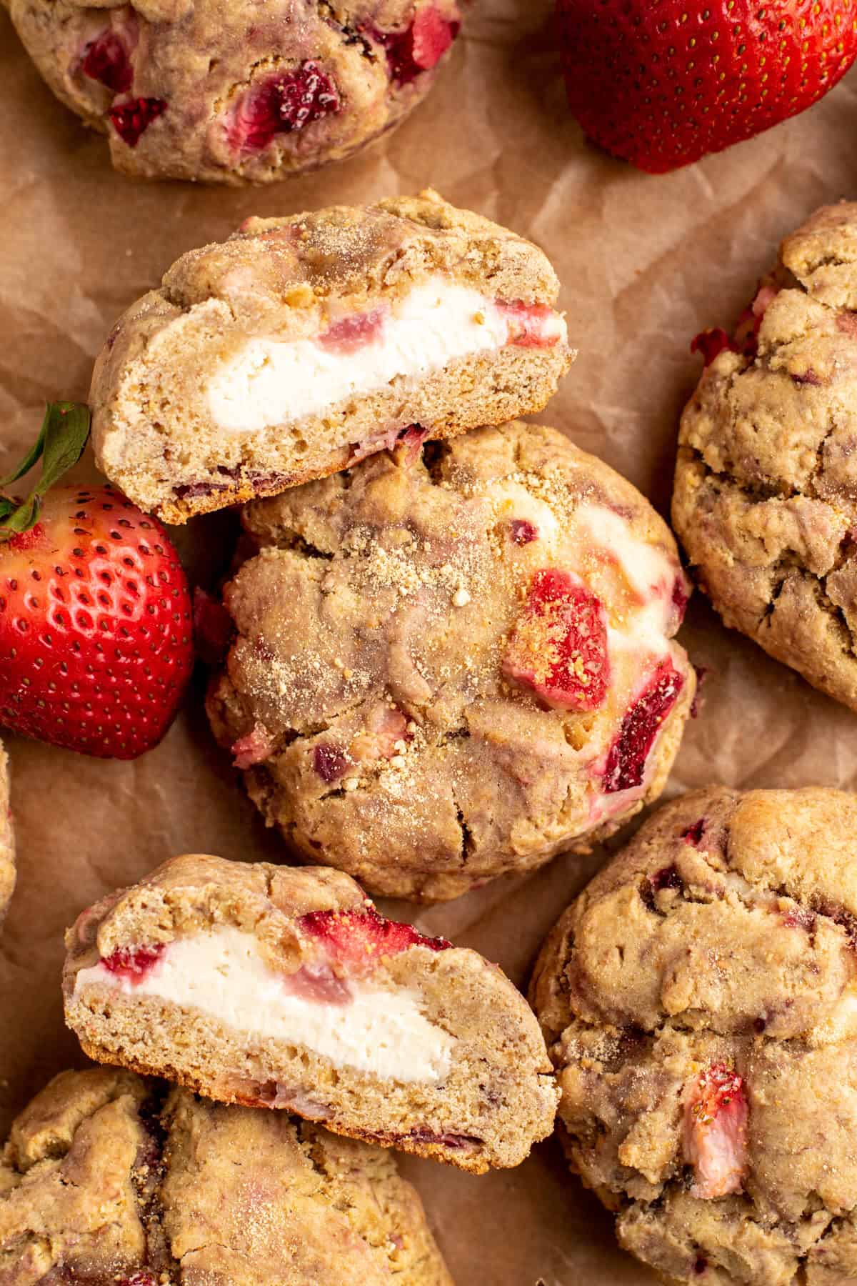 Cheesecake stuffed strawberry cookies scattered on a table.