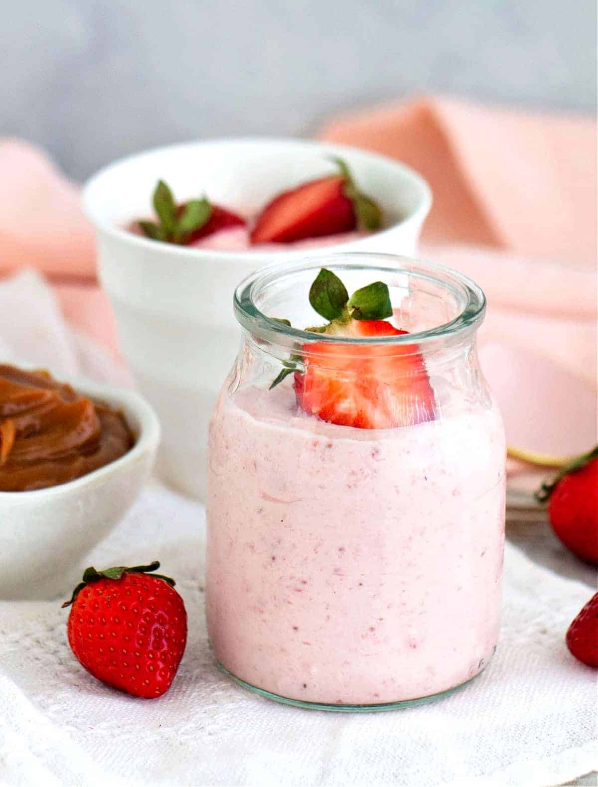 Strawberry mousse served in a small glass jar.