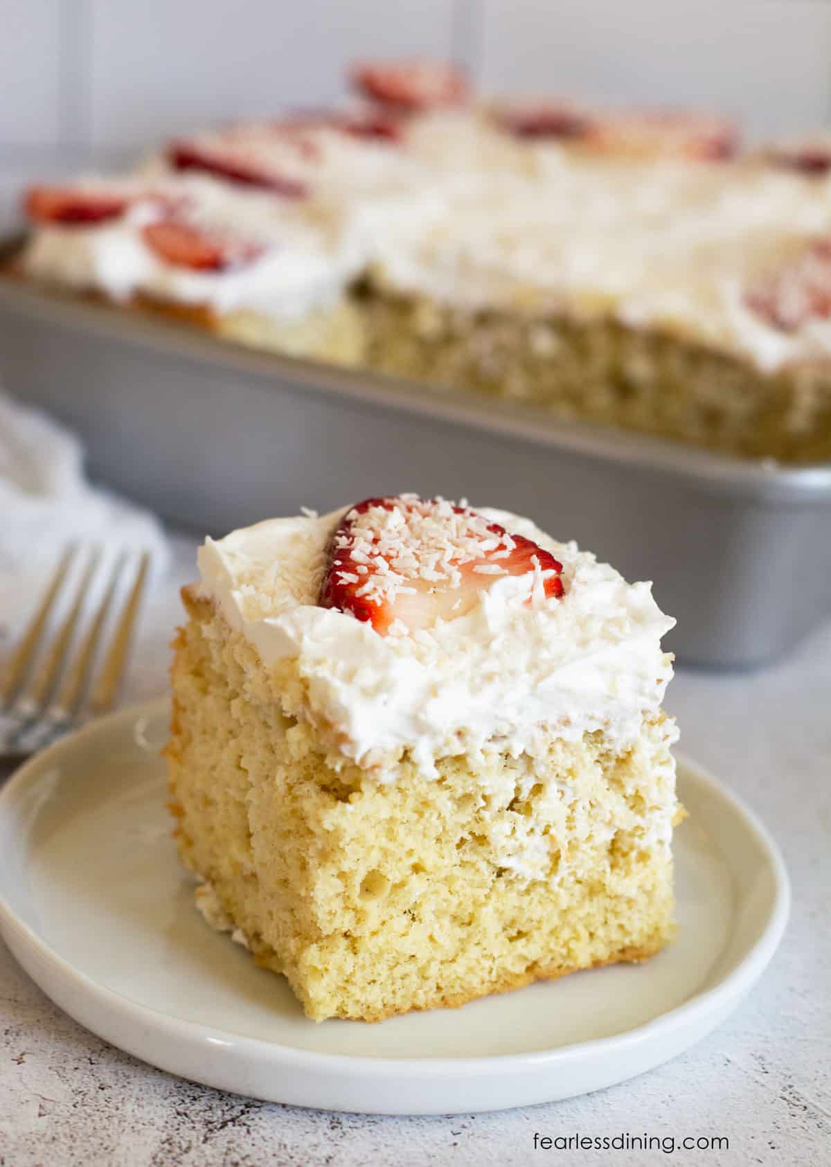 A slice of tres leches cake on a small dessert plate.