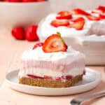 A slice of strawberry delight served on a white plate.