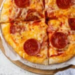 A gluten free personal pan pizza topped with dairy free cheese and pepperoni.