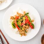 Ground chicken stir fry served over white rice on a plate.