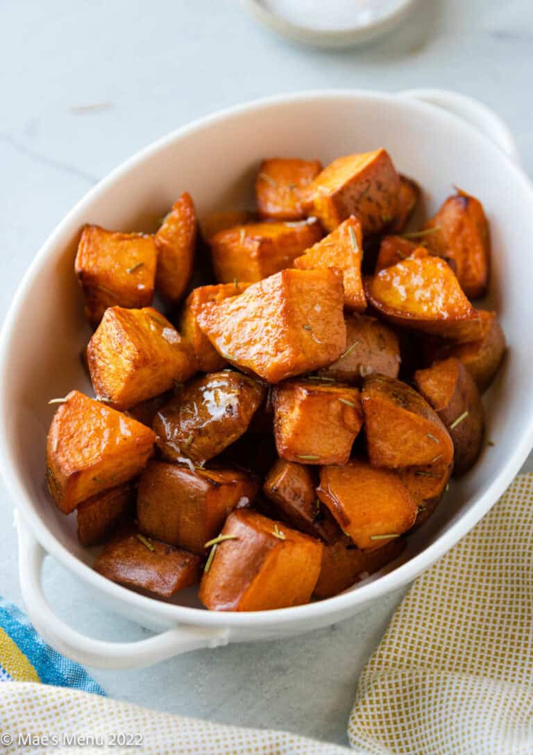 Cubes of caramelized sweet potatoes in a white serving dish.