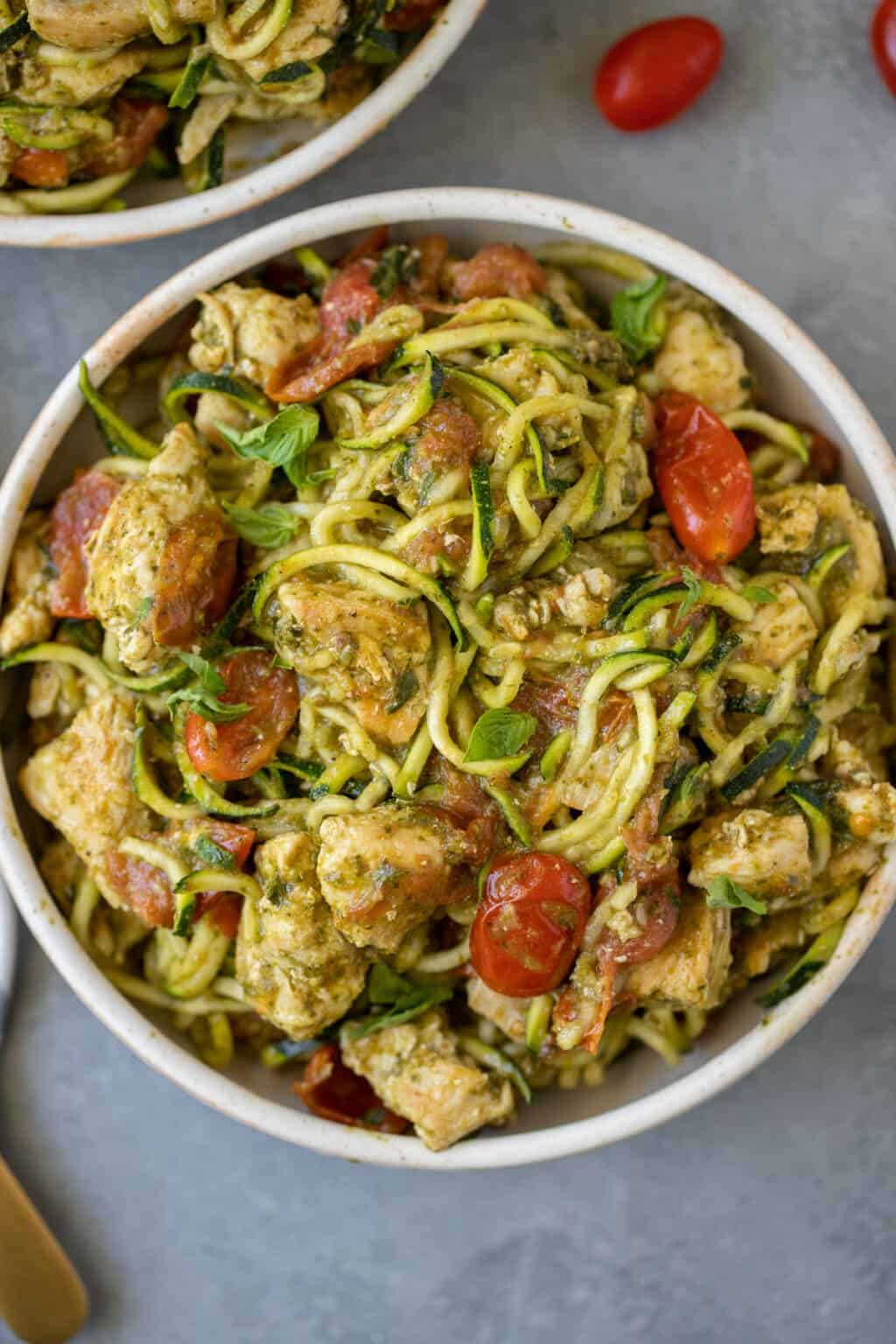 Pesto chicken with zucchini noodles in a serving bowl.