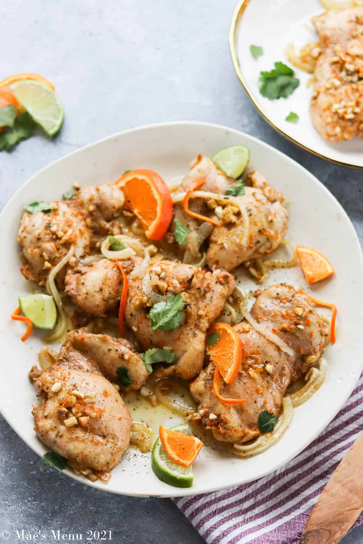 Mojo chicken topped with fresh citrus on a serving plate.