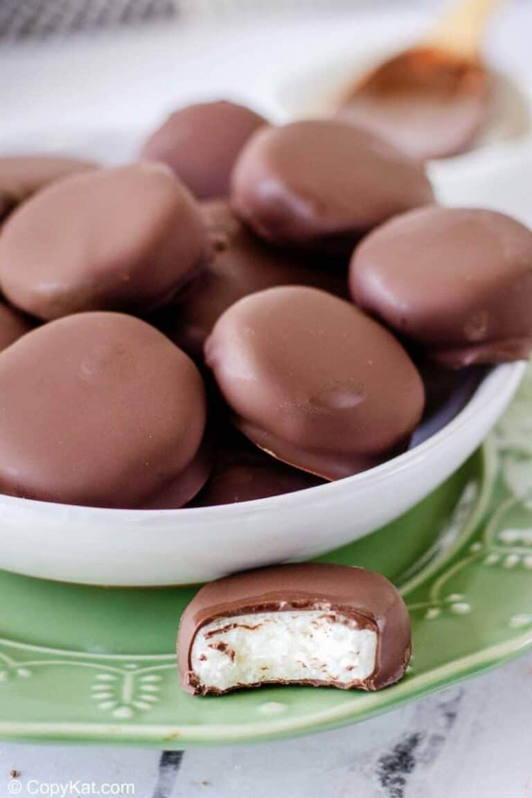 A bowl of homemade peppermint patties and one patty has a bit taken out.