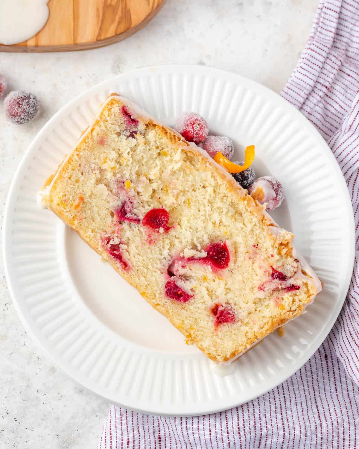 A slice of cranberry orange pound cake served on a small dessert plate.