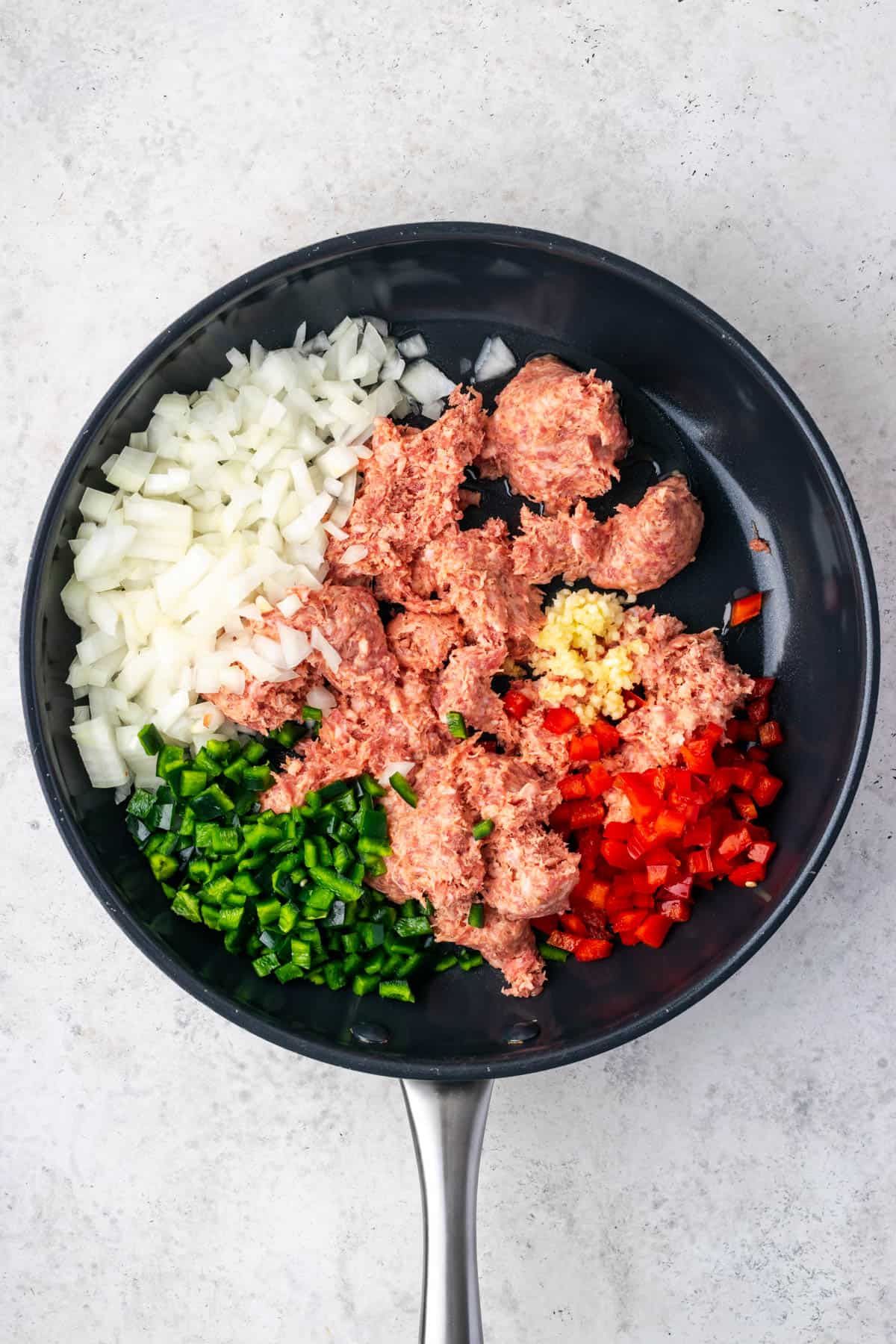 Breakfast sausage, onions, red bell pepper, Poblano pepper and garlic in a large skillet.