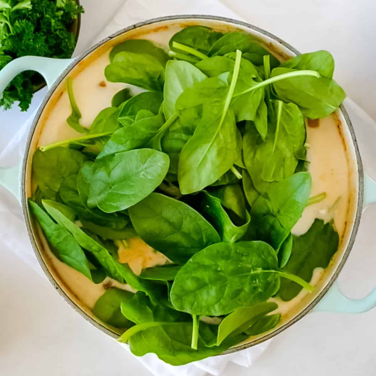 Baby spinach being added to the cooked lentil curry. 