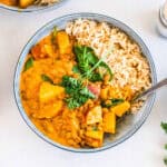 A bowl of lentil curry served over brown rice.