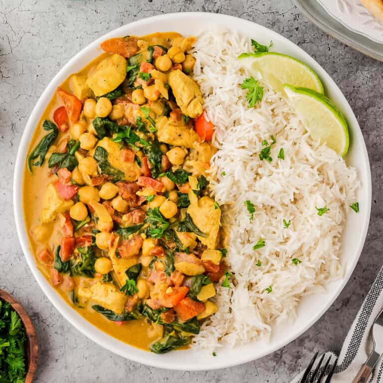 A plate of chicken and chickpea curry served with basmati rice.