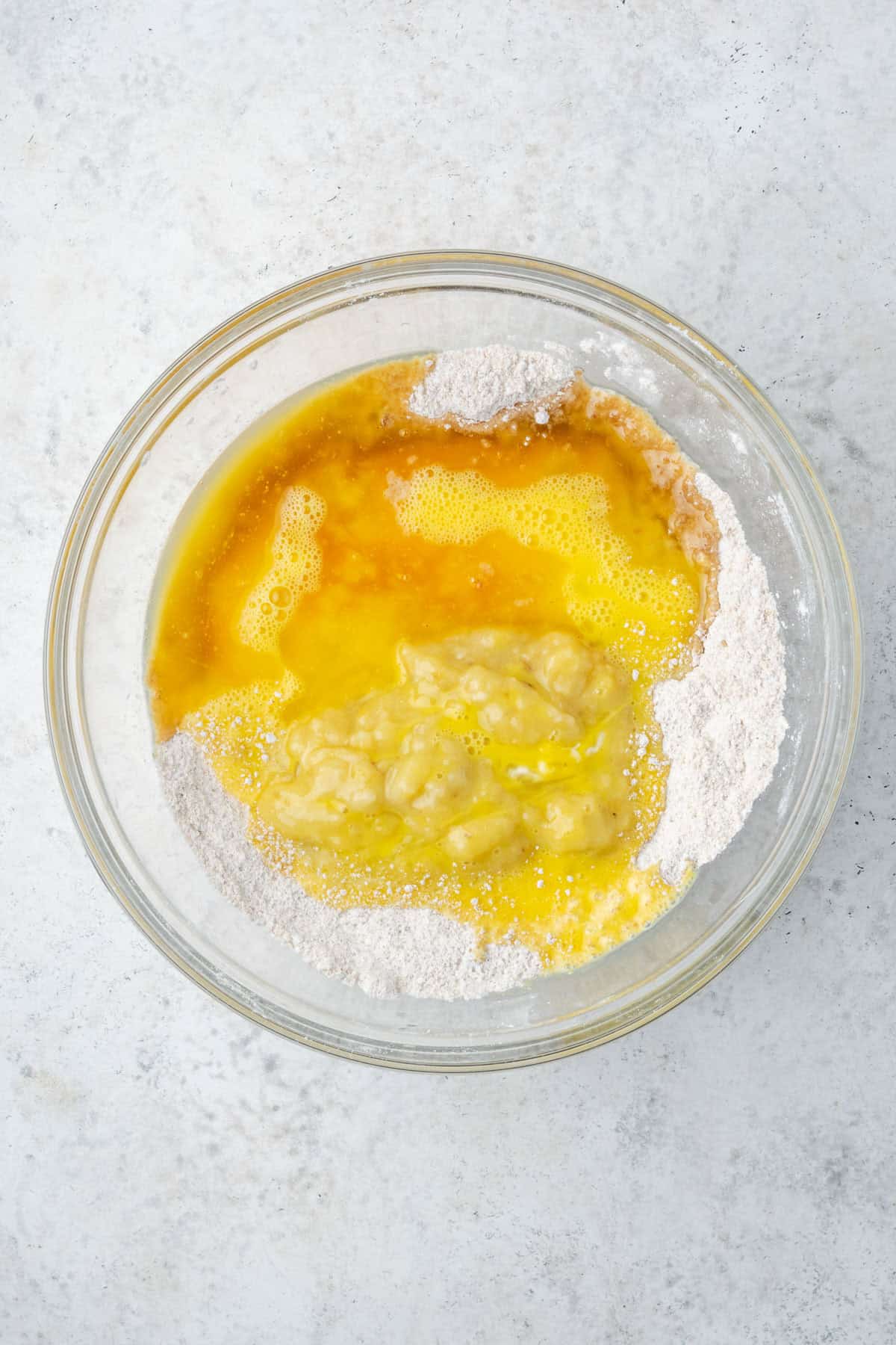 Melted butter, mashed bananas, beaten eggs, vanilla and rum added to the bowl with the dry ingredients. 