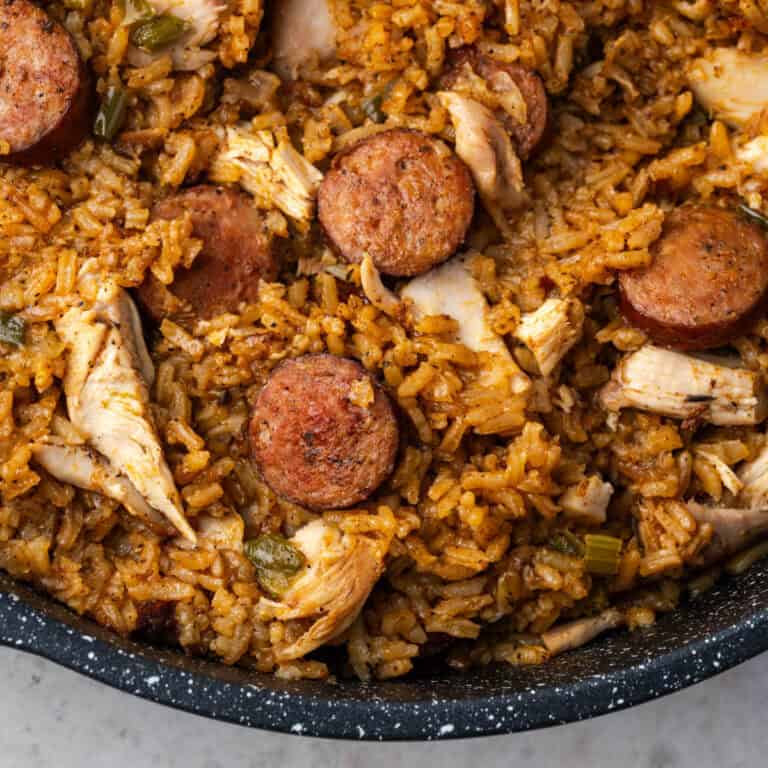 Cajun style chicken and sausage jambalaya in a large black pot.