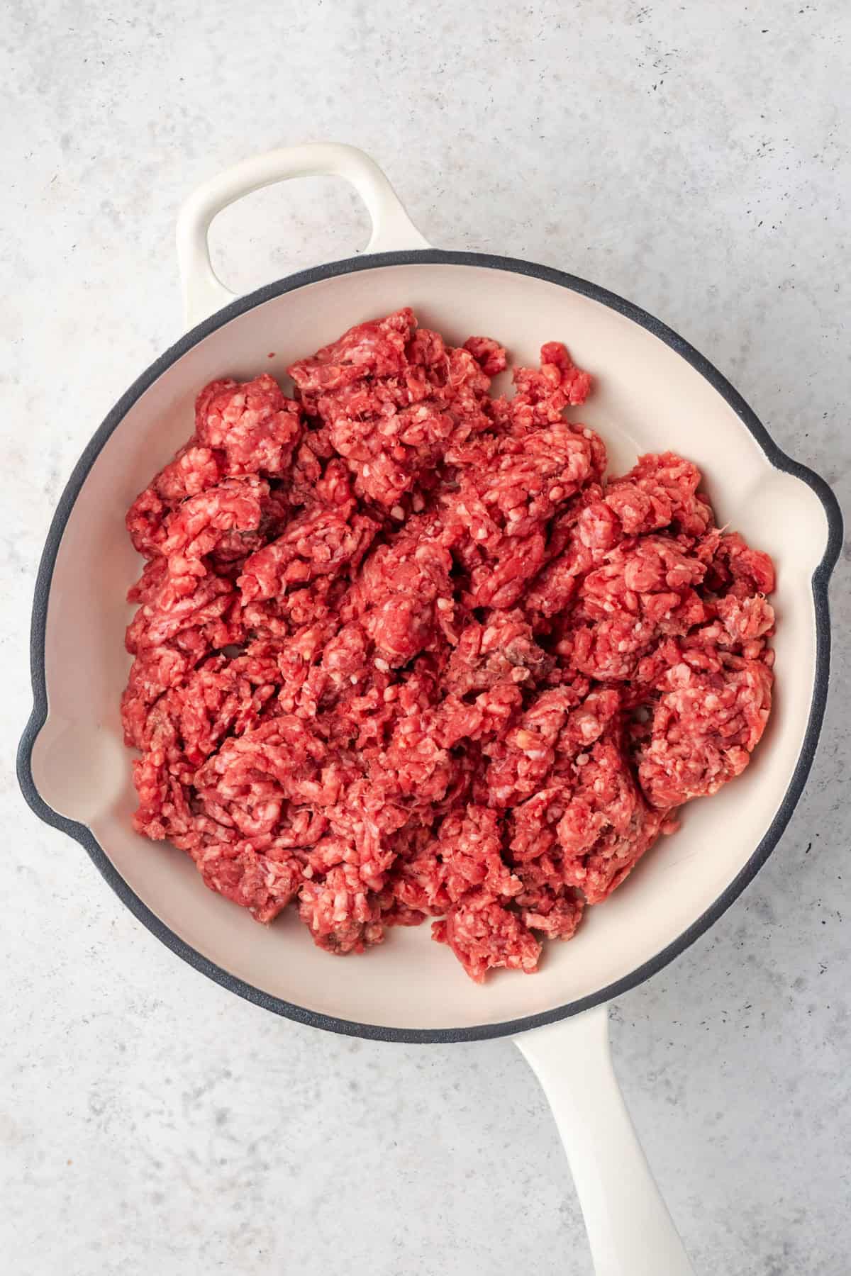 Ground beef cooking in a large skillet. 