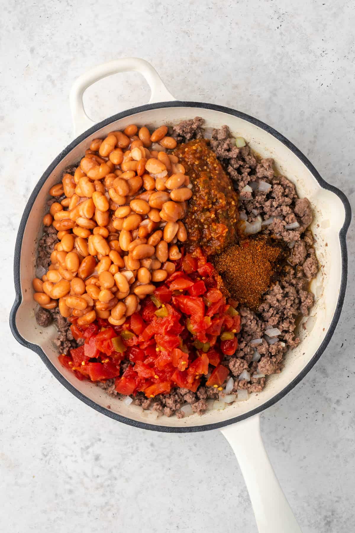 Taco seasoning, beans, tomatoes and salsa added to the cooked beef. 