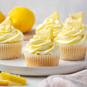 Several gluten free lemon cupcakes sitting on a ceramic tray.