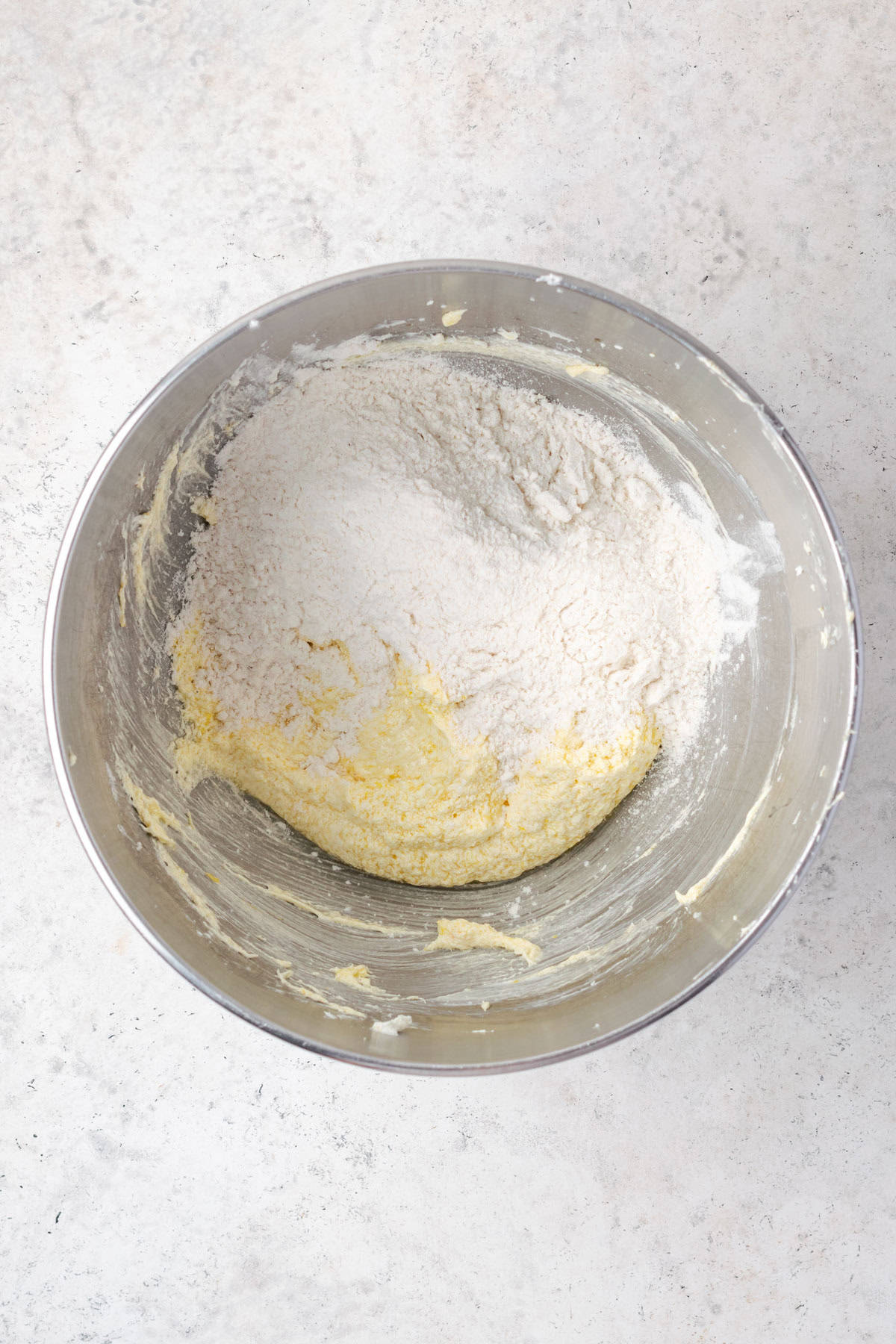 Dry ingredients being stirred into partially mixed cupcake batter.