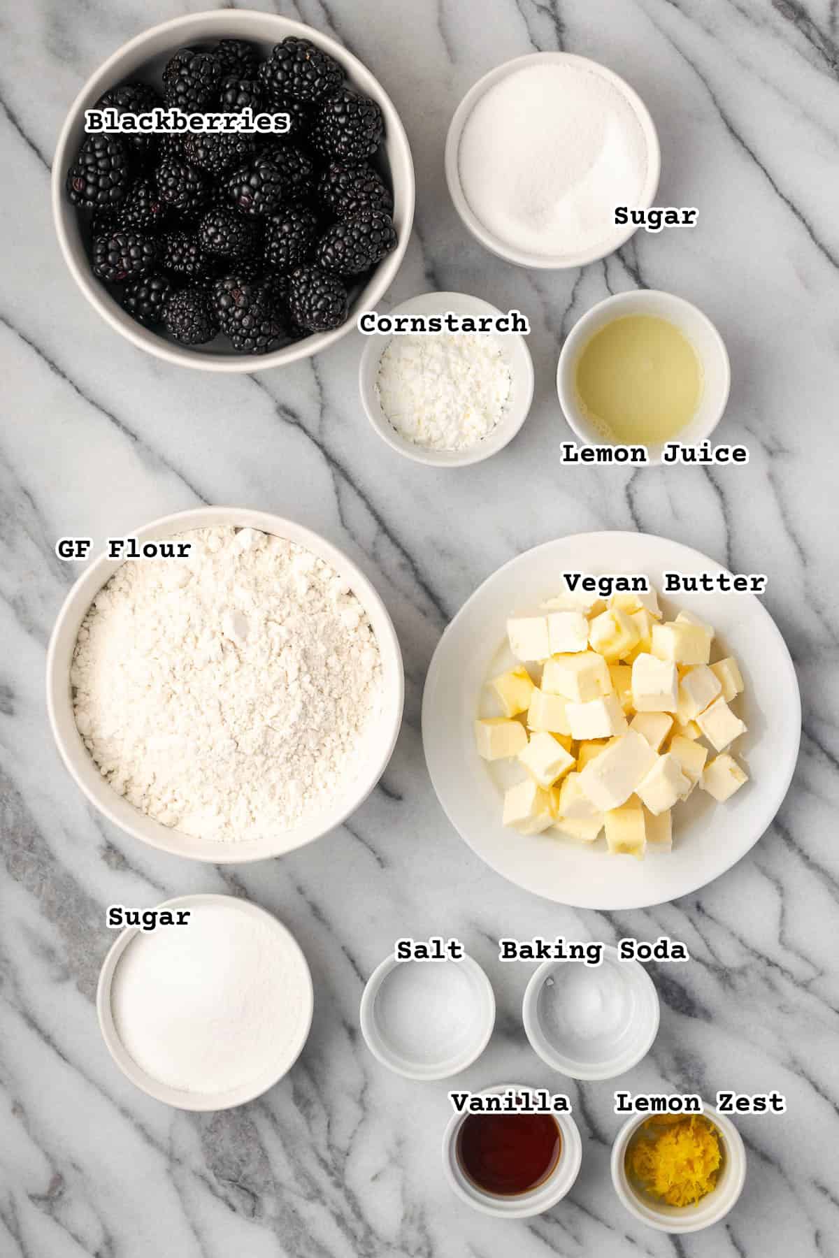 Ingredients for blackberry pie bars sitting on a marble counter.