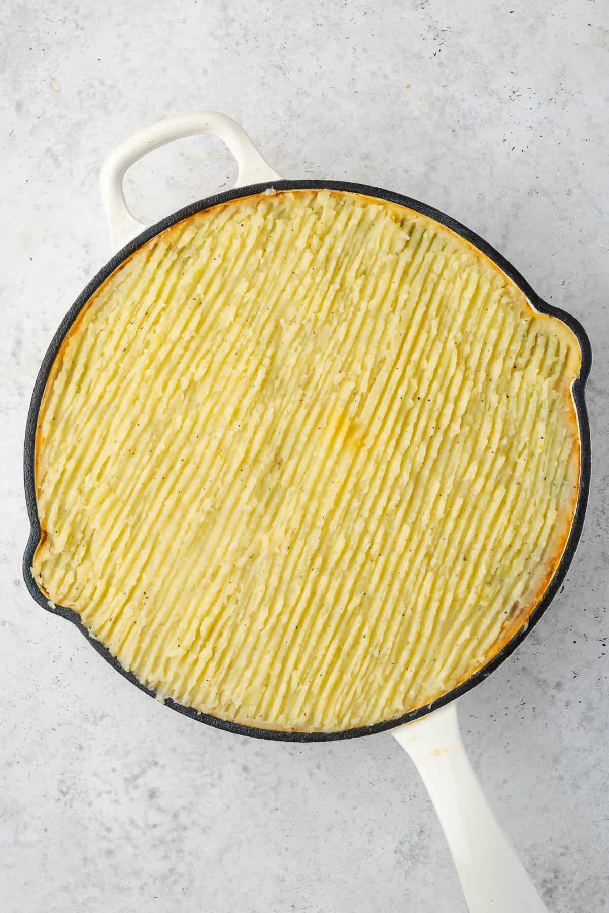 An unbaked pan of gluten free cottage pie. 