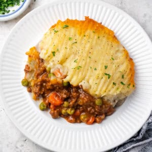 A portion of gluten free cottage pie served on a dinner plate.