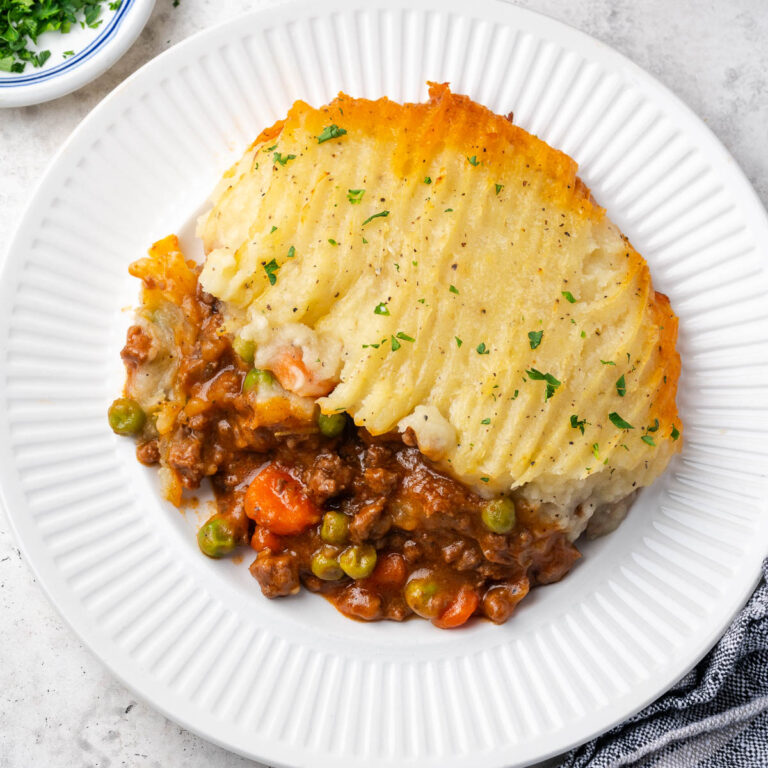 A portion of gluten free cottage pie served on a dinner plate.