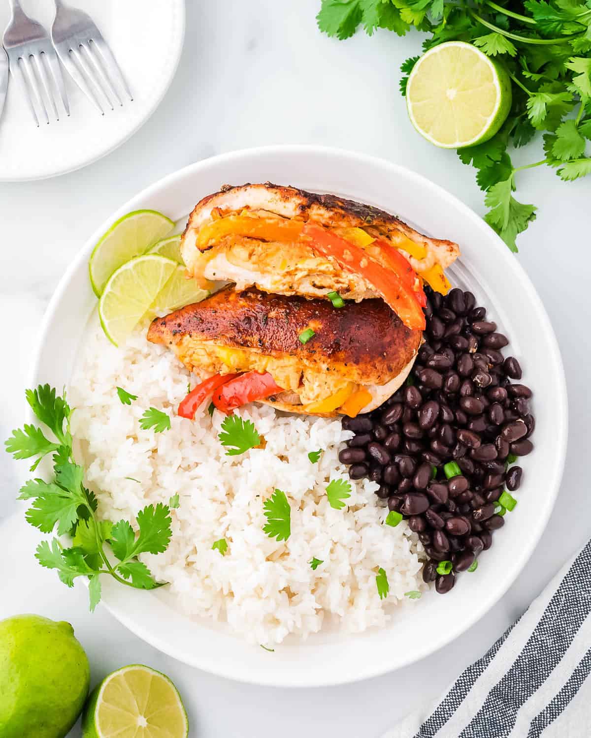 Two fajita stuffed chicken breasts served with white rice and black beans. 