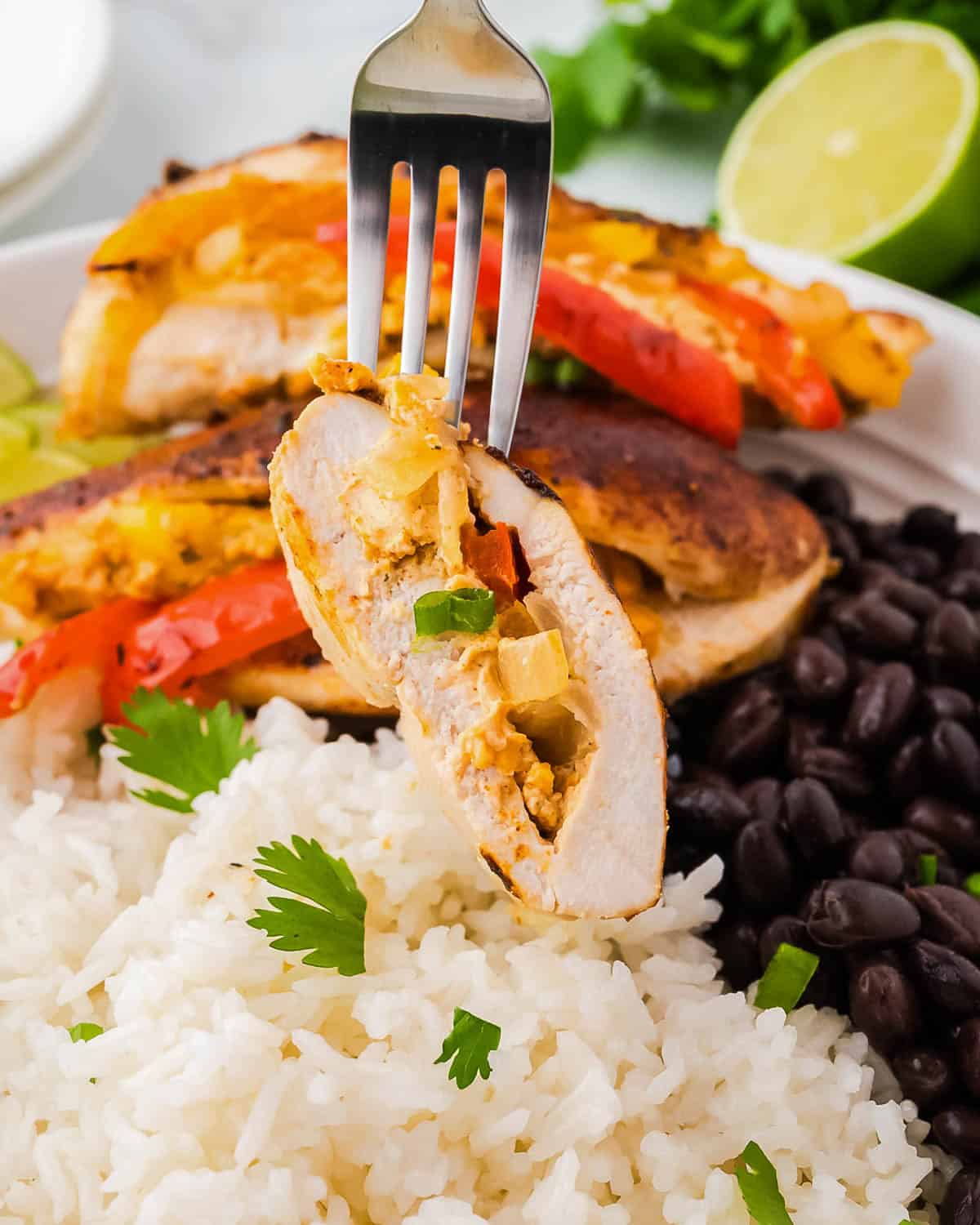 A bite of a fajita stuffed chicken breast on a fork. 