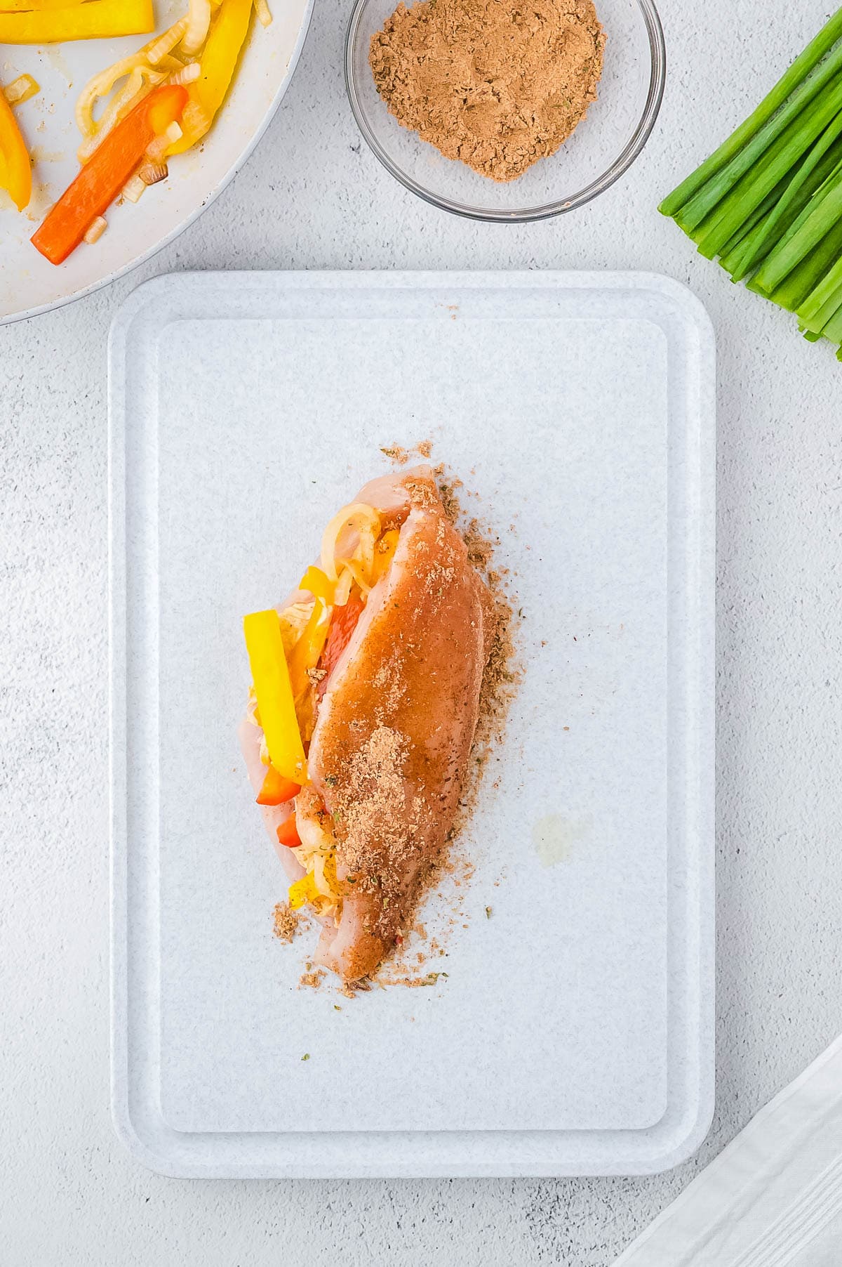 Chicken breast folded closed over the filling and topped with fajita seasoning. 