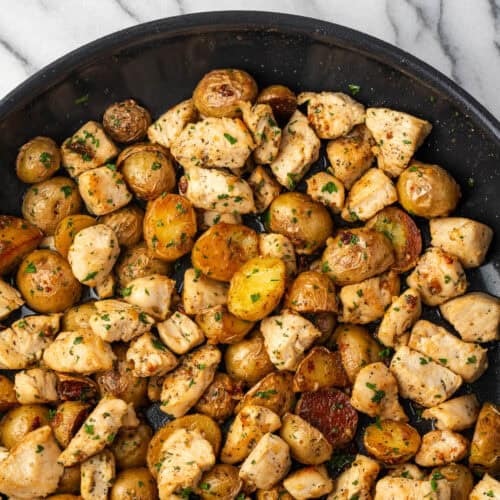 Cooked chicken and potatoes in garlic butter in a large skillet.