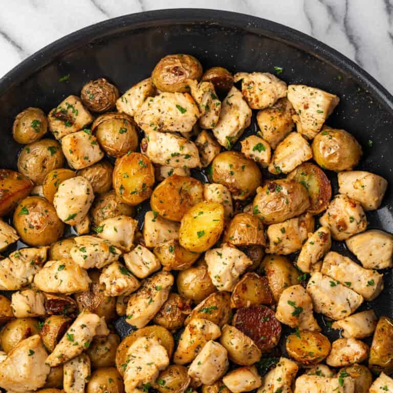 Cooked chicken and potatoes in garlic butter in a large skillet.